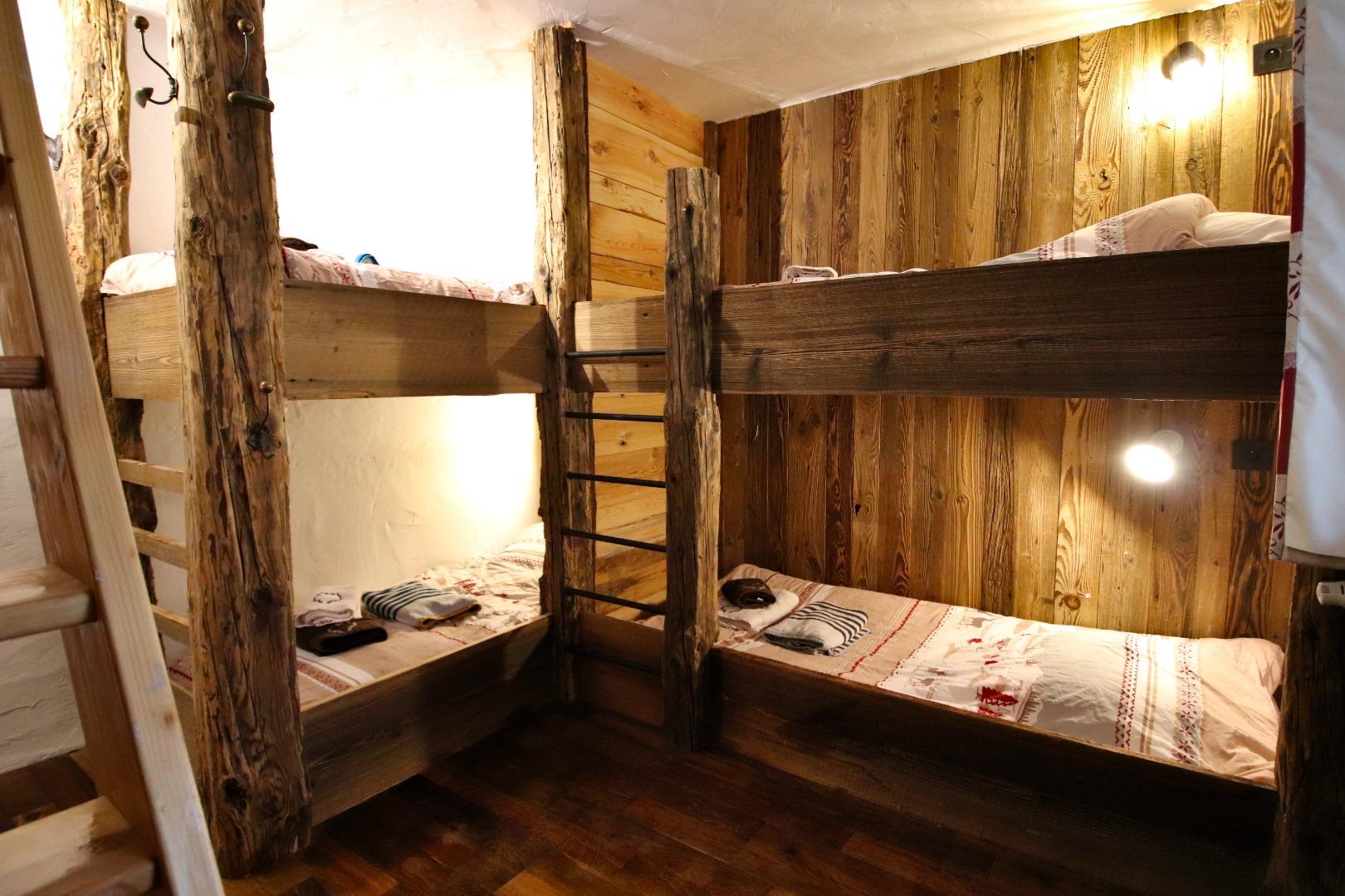 La chambre 4, un des deux dortoirs meublée de 4 couchages en lits superposés fait sur mesure en vieux bois, et d'une mezzanine avec 2 lits simples.