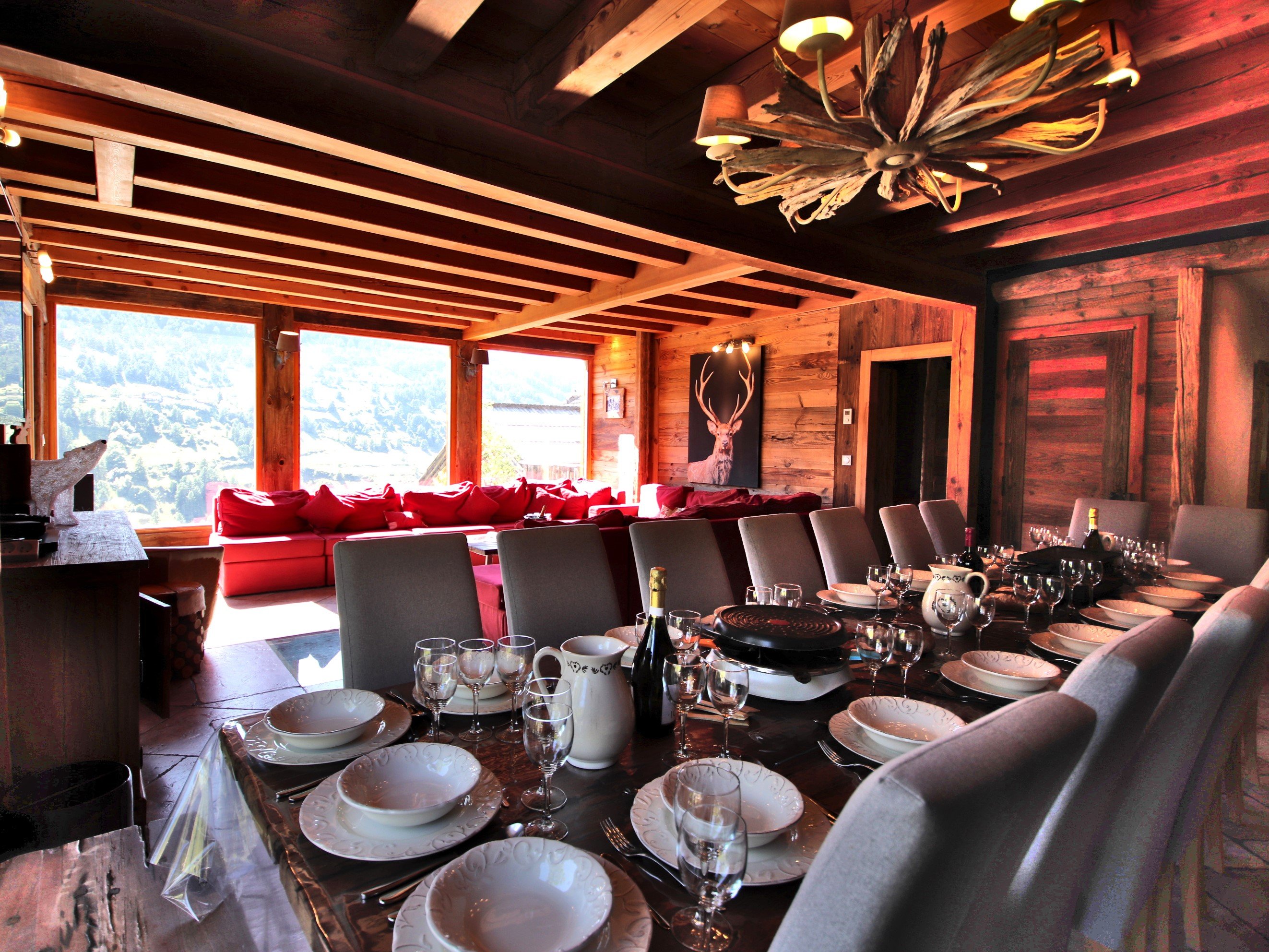 Repas montagnard  : table de salle à manger pour 19 convives prête pour une raclette face au panorama de la montagne