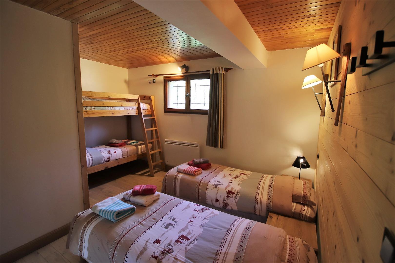Chambre 2 au R0 meublée de 2 lits jumeaux (présentés sur la photo en version 2 lits simples mais que l'on peut assembler pour former un lit double) et d'un lit superposé.