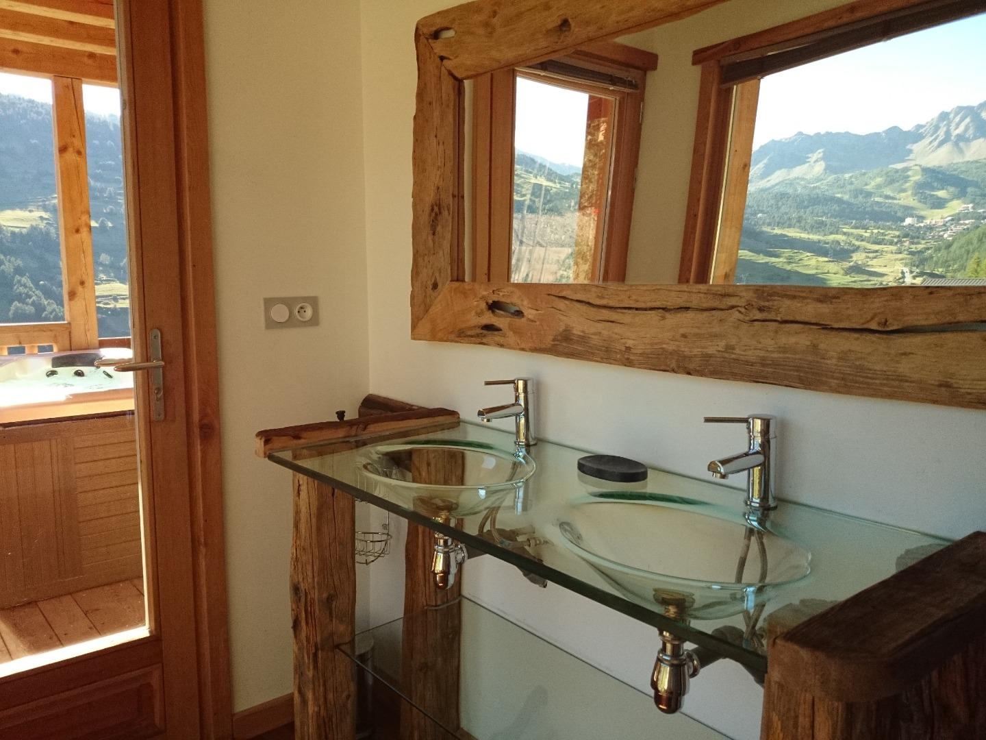 La salle de bain au R0 partagée par les chambres 2 et 3. Elle est équipée d'une douche balnéo hammam et d'une double vasque vitrée. 

Accédez à la terrasse du jacuzzi par la porte à gauche, et profitez de la meilleure vue de Vars.
